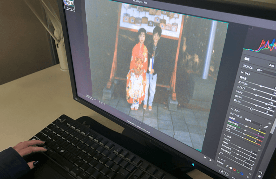 写真修復スタッフがPC画面でレタッチ作業をしている様子